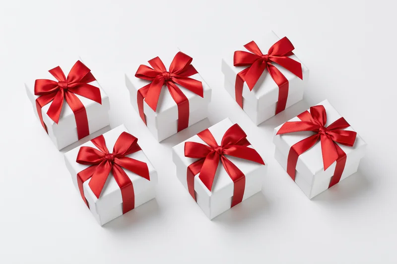 Six white gift boxes with red ribbons arranged in two rows on a white surface