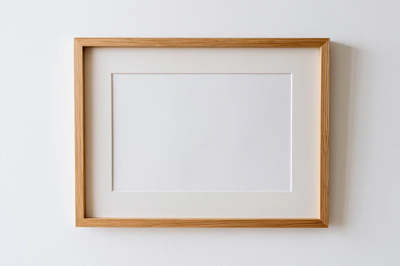 Light oak wooden picture frame with blank white interior hanging on a white wall