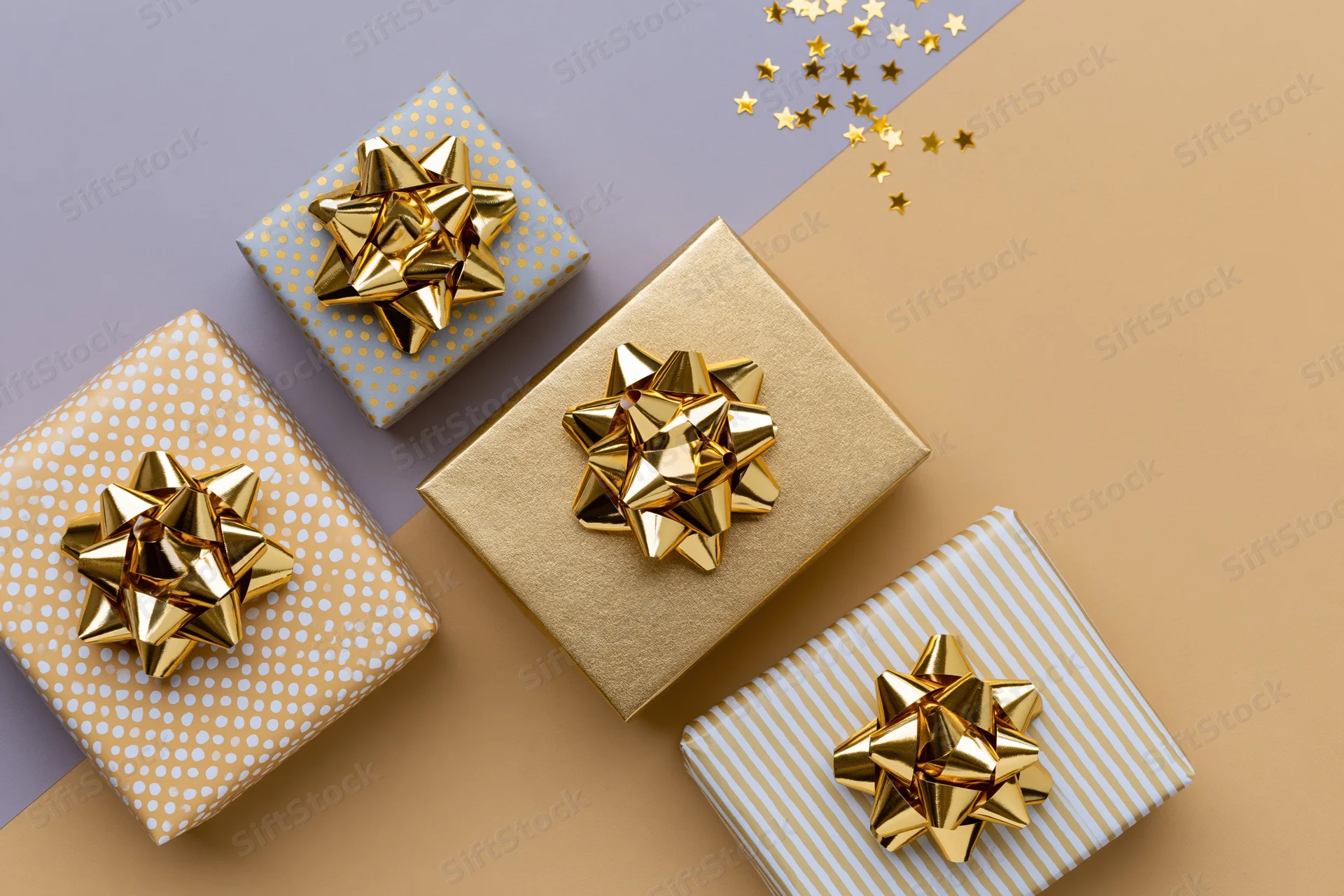 Four gift boxes with gold foil bows arranged diagonally on a two-tone pastel background