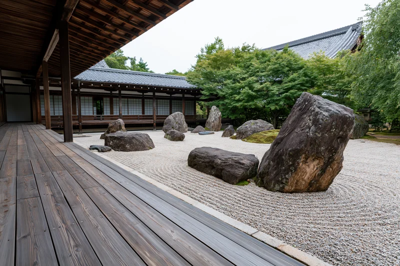 Traditional japanese zen garden with raked gravel and large rocks beside a wooden veranda