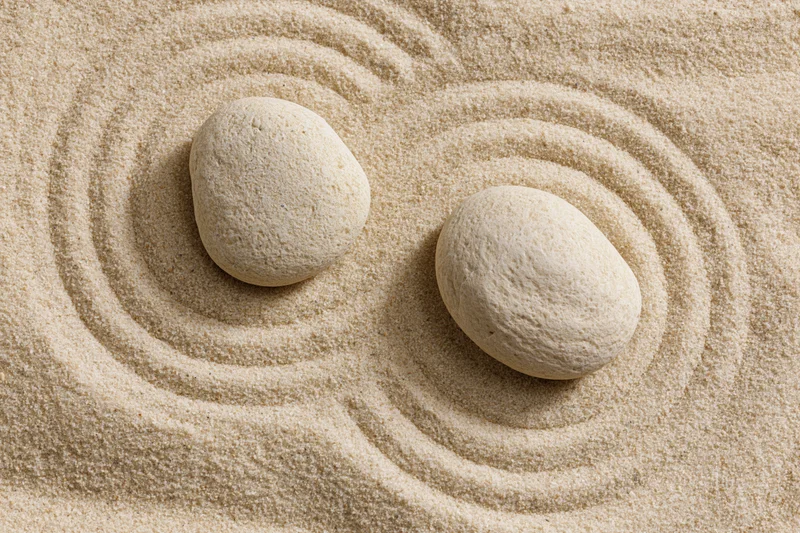 Two smooth stones resting on raked sand in a zen garden