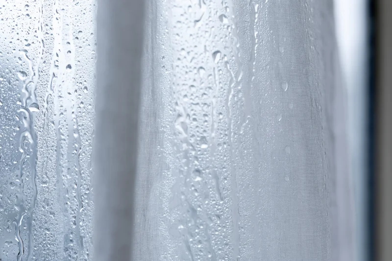 Water droplets condensed on a glass window pane in closeup view