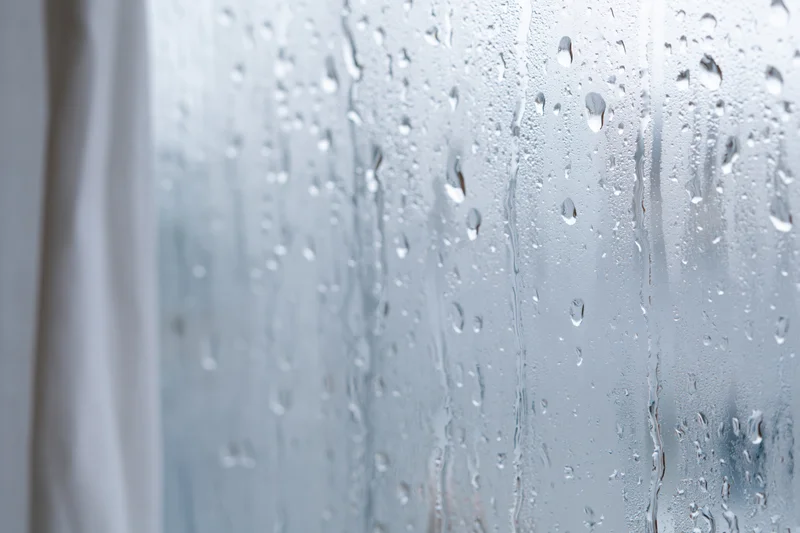 Water droplets condensed on a glass window pane in closeup view