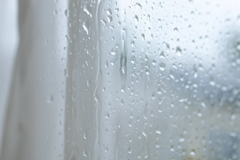 Water droplets condensed on a glass window pane in closeup view