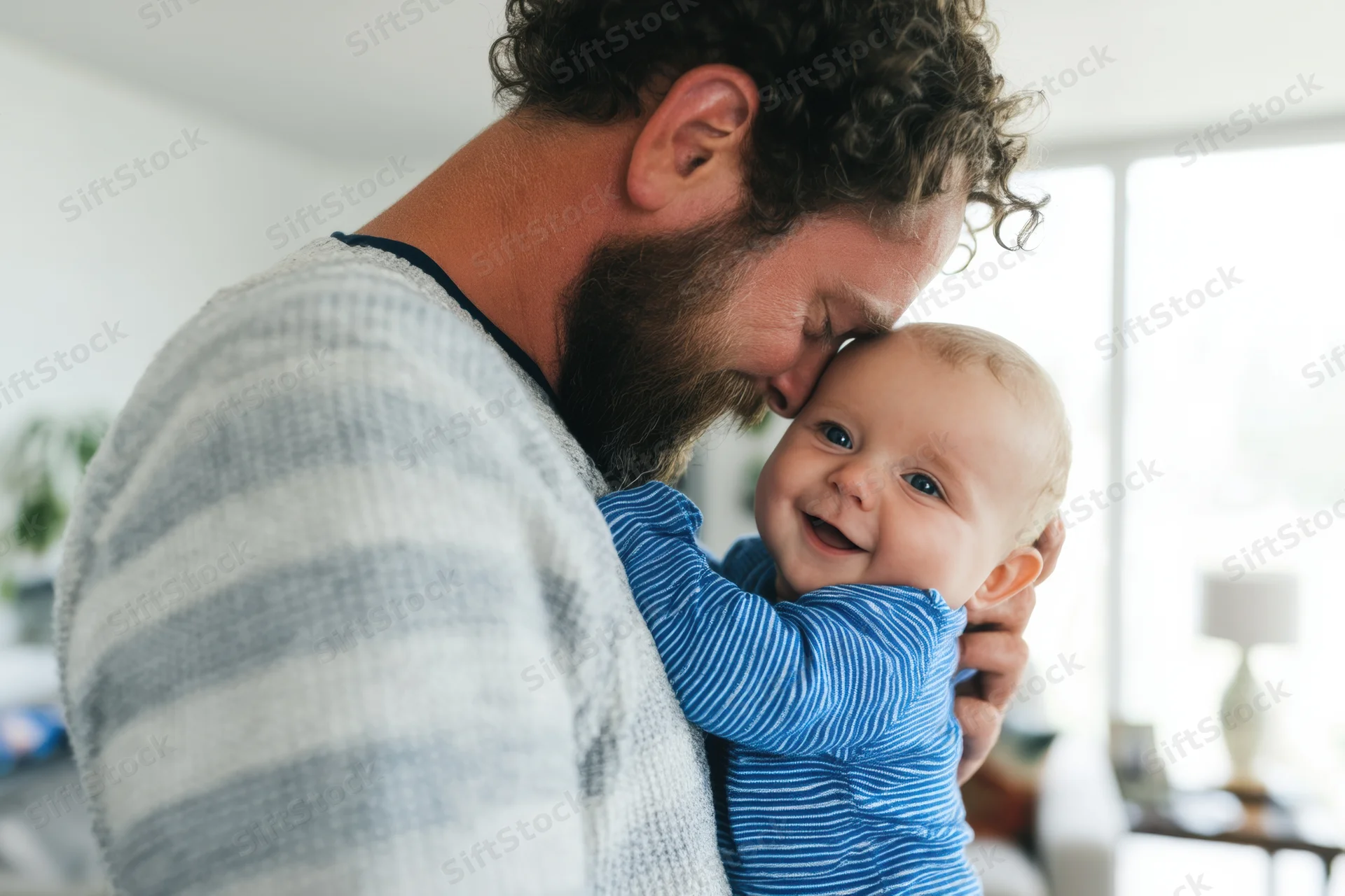 Father cradling smiling baby in living room interior