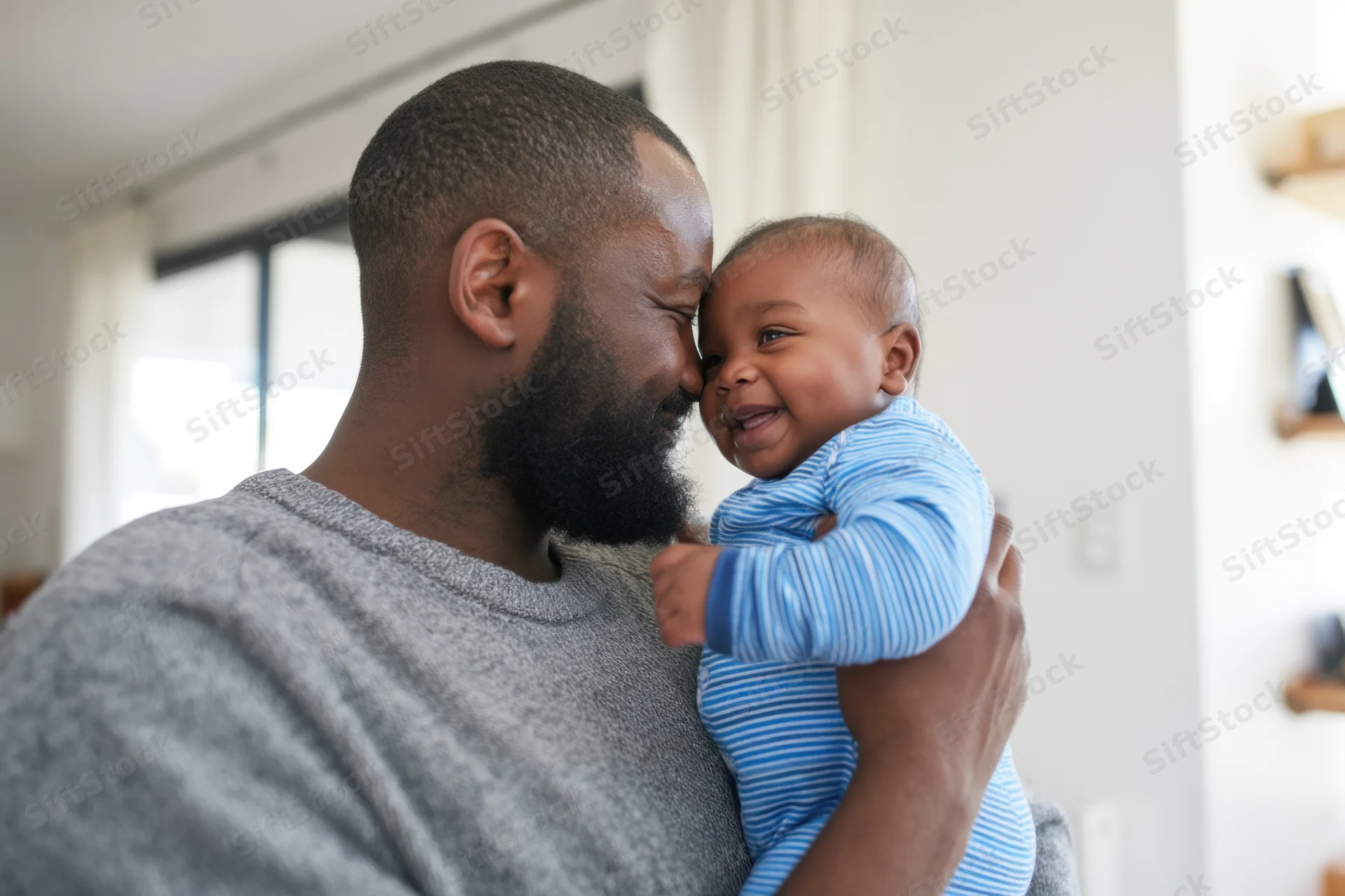 Father cradling smiling baby in home setting