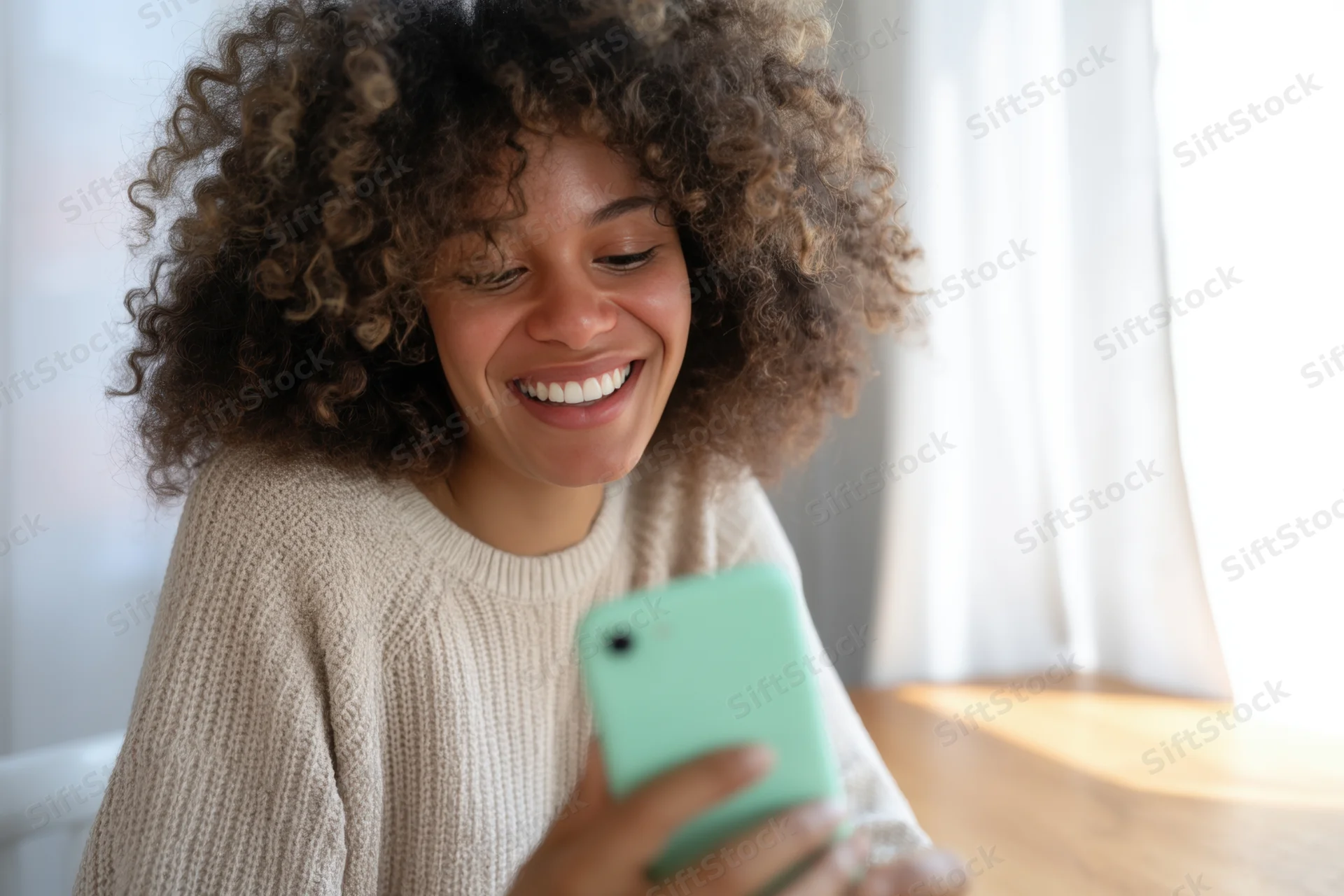 Woman smiling while holding smartphone indoors