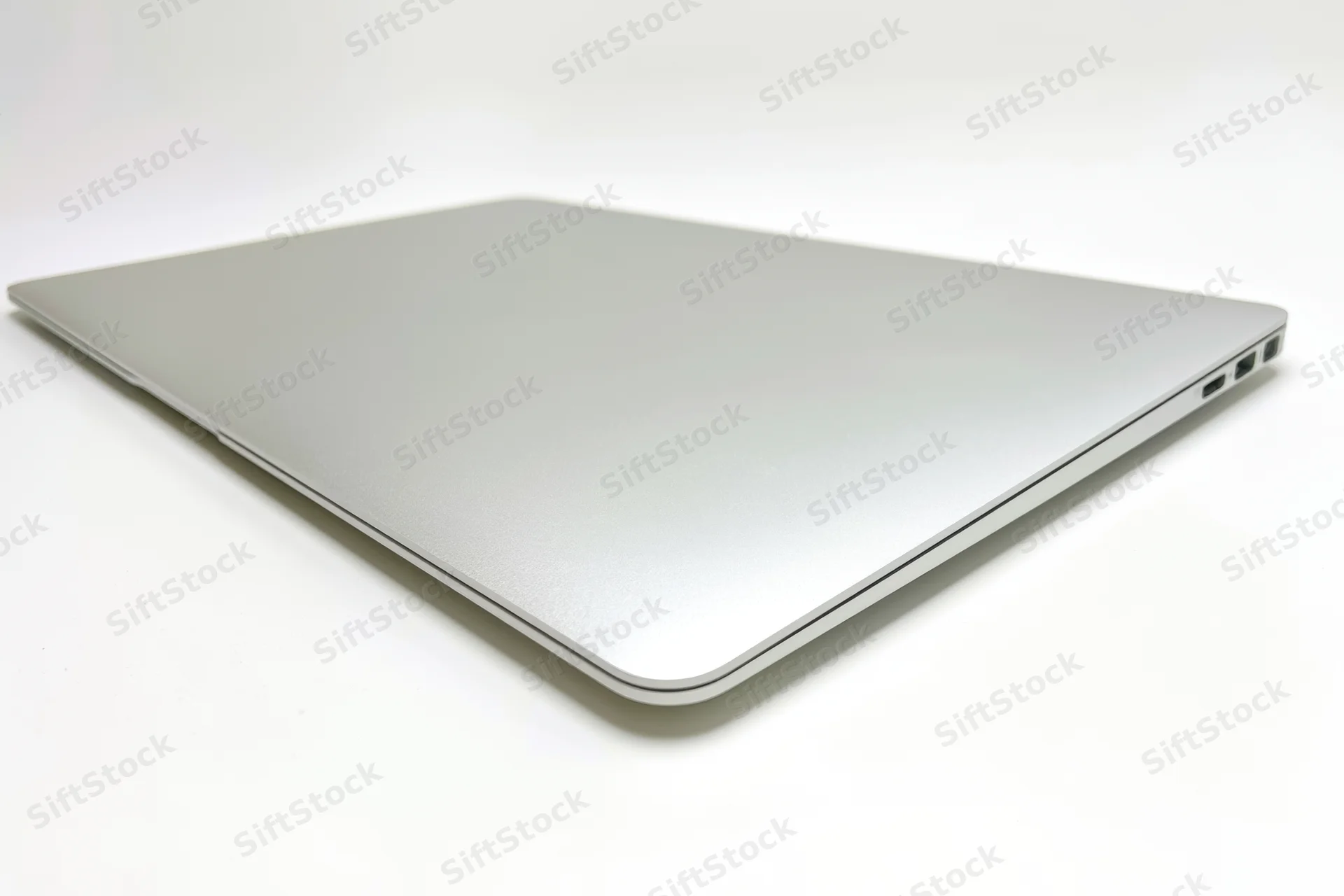 Closed silver laptop viewed from the back on a white background