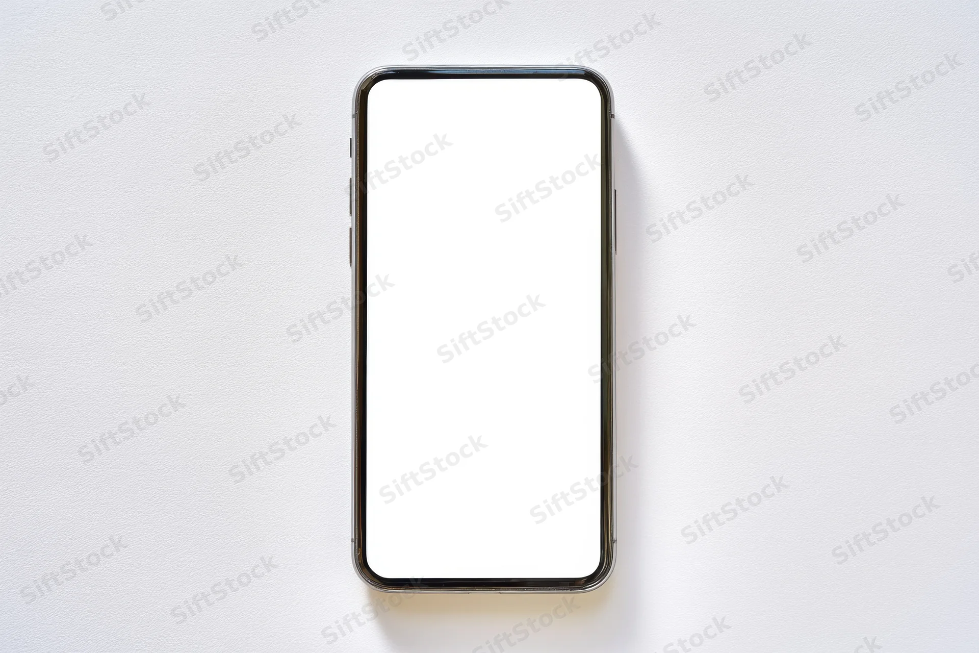 Modern smartphone with blank white screen lying flat on white surface