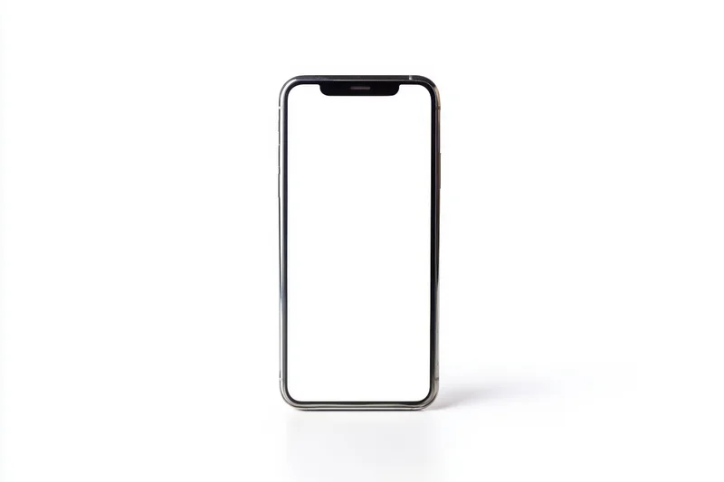 Modern smartphone with blank white screen standing upright on white surface