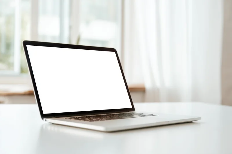Sleek laptop with blank white screen on white desk near window