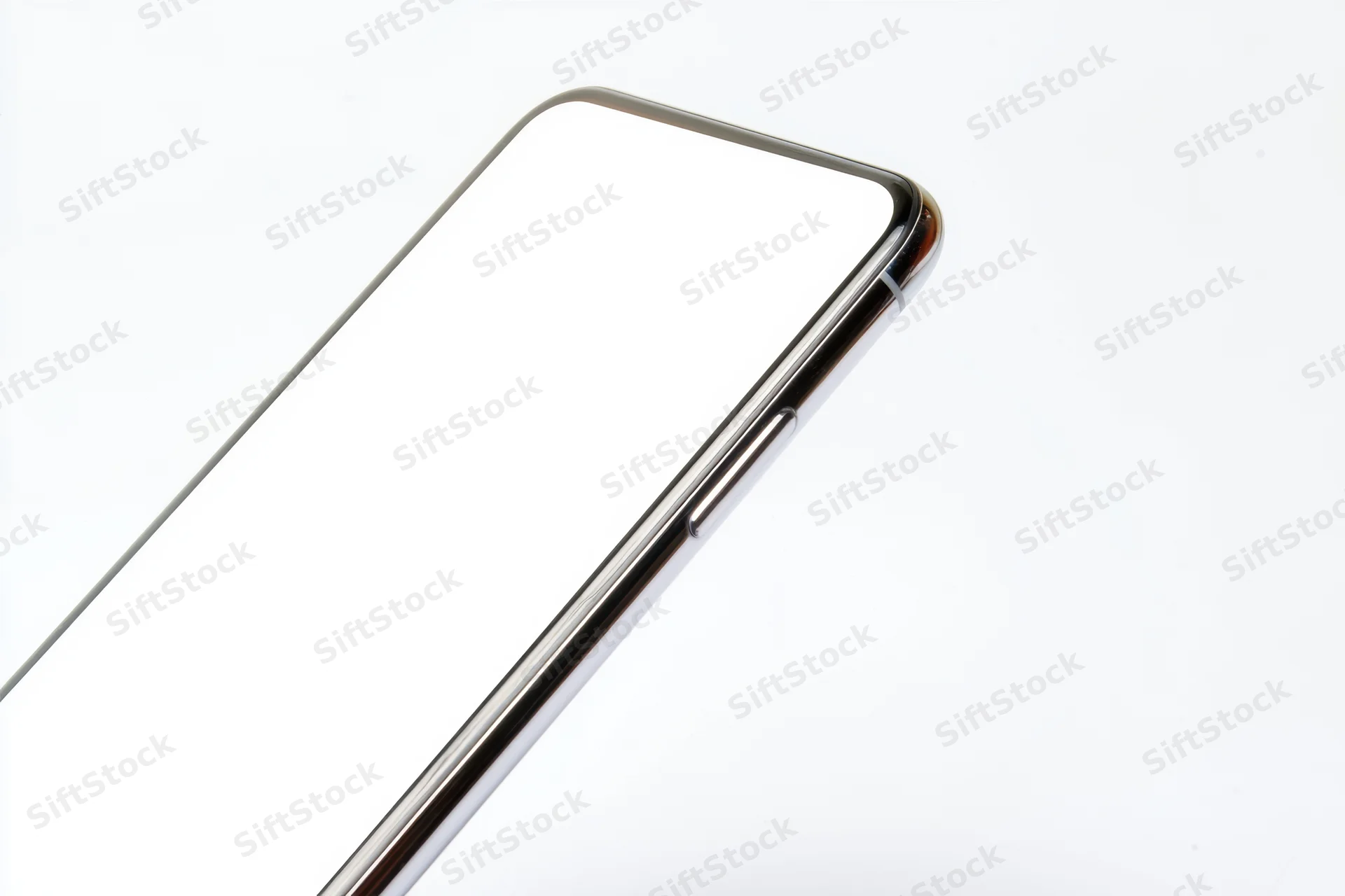 Tilted smartphone with blank white screen and metallic frame showing curved edge and side buttons against white background