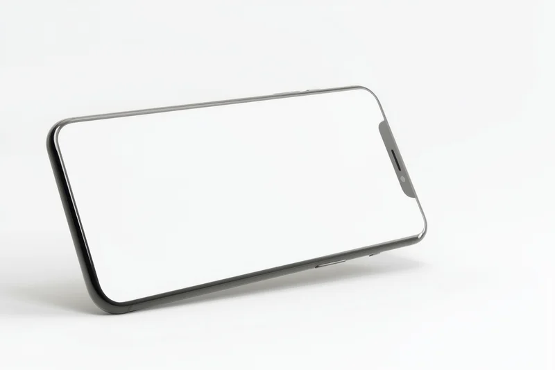 Smartphone with blank screen lying on white surface