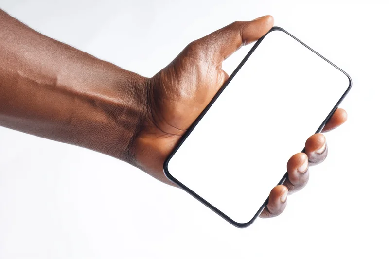 Hand holding a smartphone with blank white screen against white background