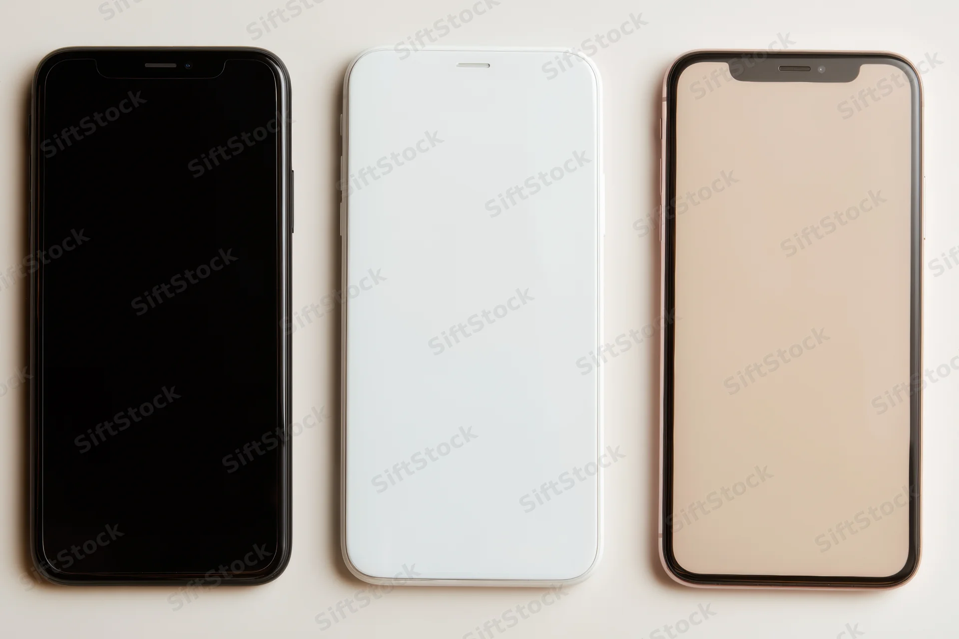 Three smartphones with blank screens arranged side by side on a light surface