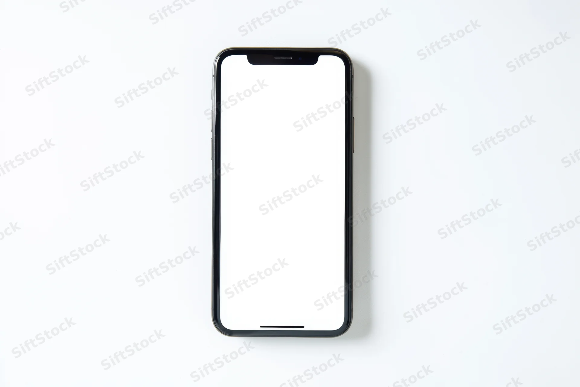 Black smartphone with white screen lying flat on white surface
