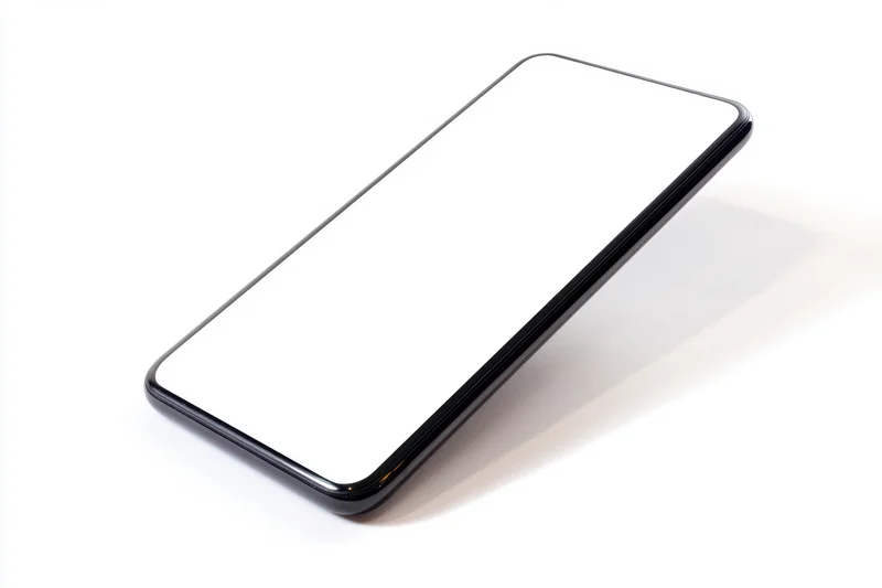 Sleek smartphone with blank white screen angled on white surface
