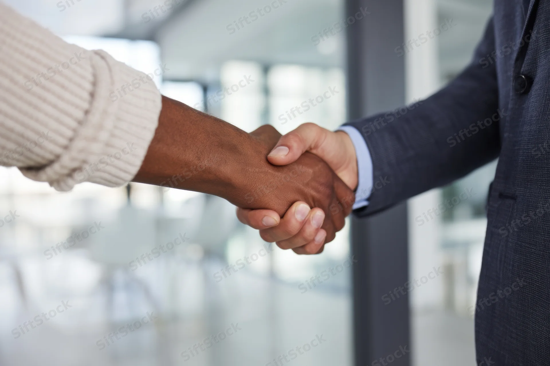 Close-up of two professionals shaking hands in an office setting