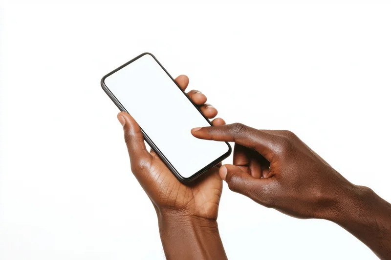 Dark-skinned hands holding and touching a smartphone with a blank white screen against a white background