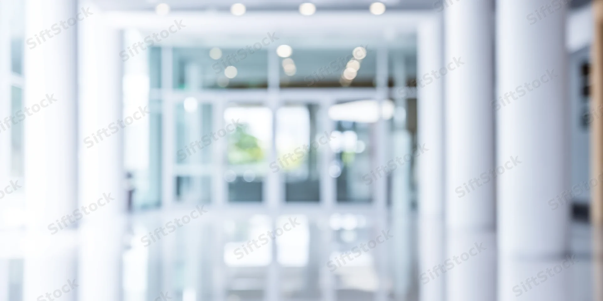 Blurred entrance to modern glass building interior hallway