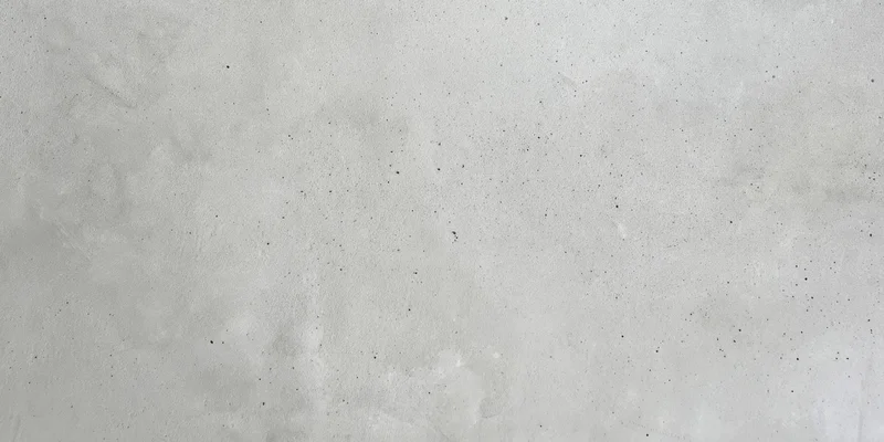 Close-up of a light gray concrete wall with a slightly rough texture
