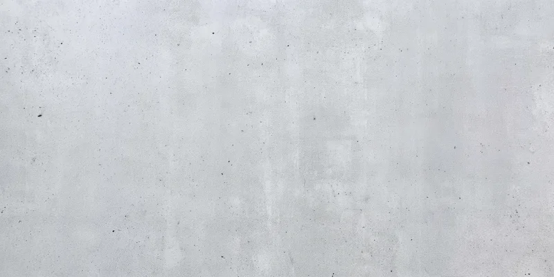 Close-up of a light gray concrete wall with a rough textured surface
