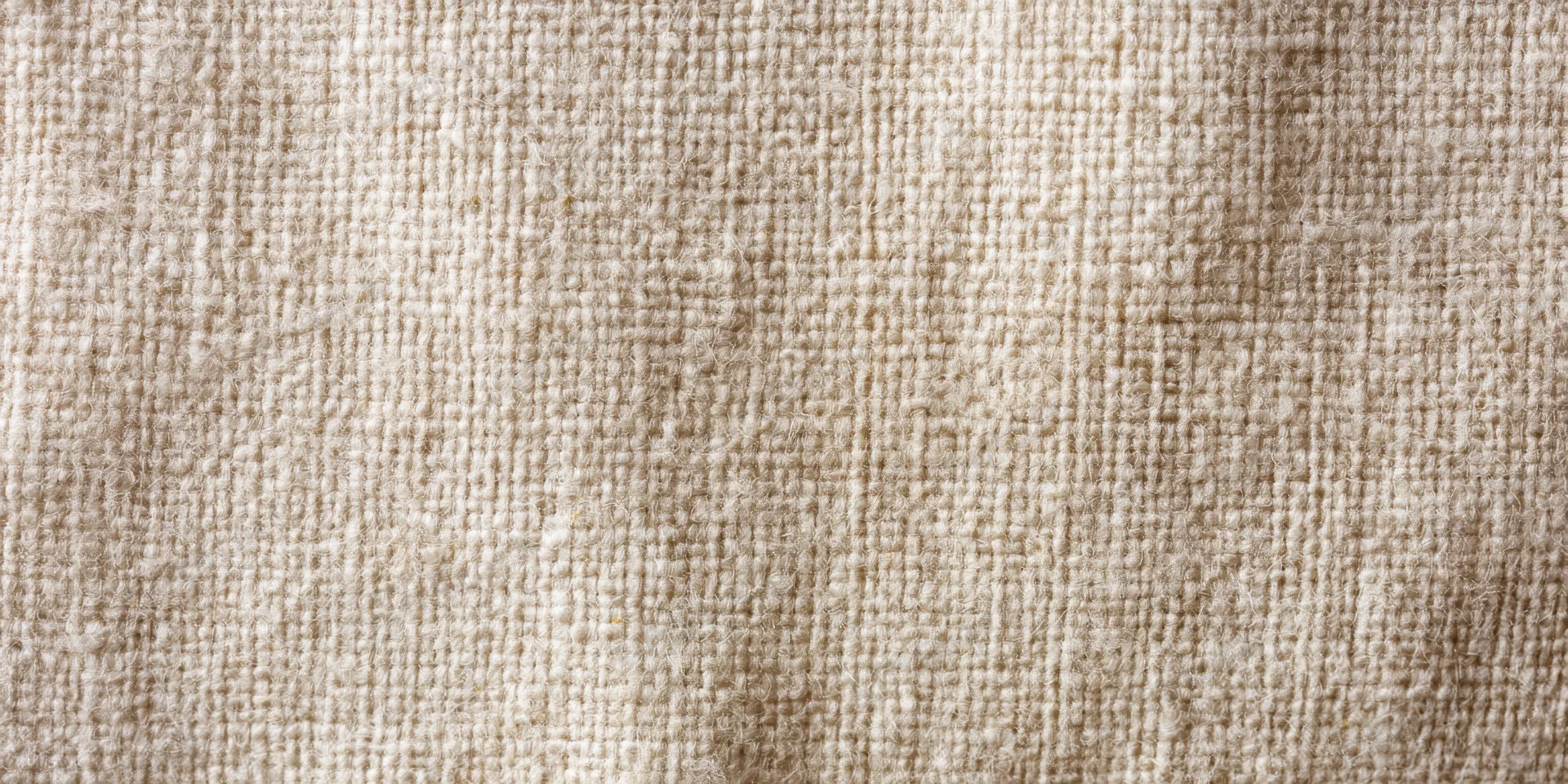 Close-up of beige linen fabric showing its woven texture and natural weave pattern