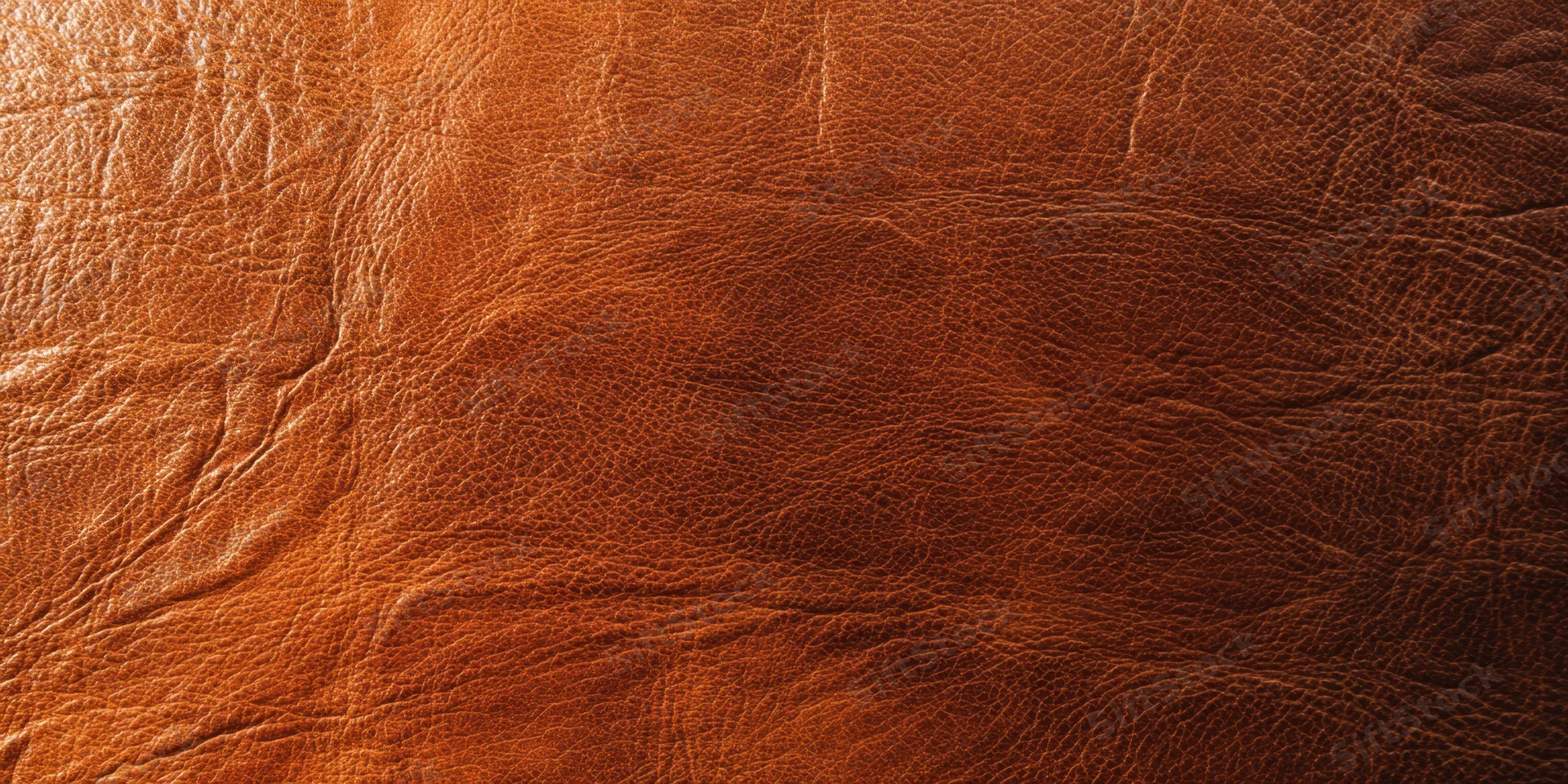 Close-up of rich brown leather texture with pronounced grain and natural creases