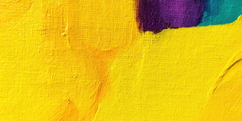 Close-up of textured canvas with bright yellow paint and purple and teal accents