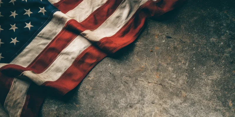 Weathered american flag lying on rough concrete surface