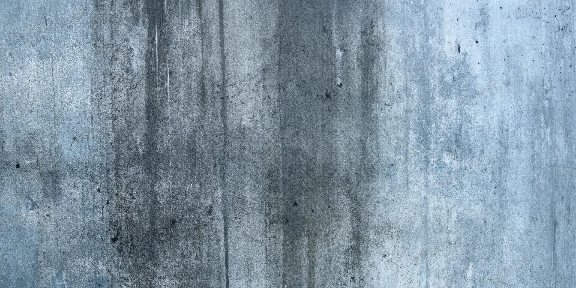 Close-up of a weathered concrete wall with vertical grime streaks and textured surface