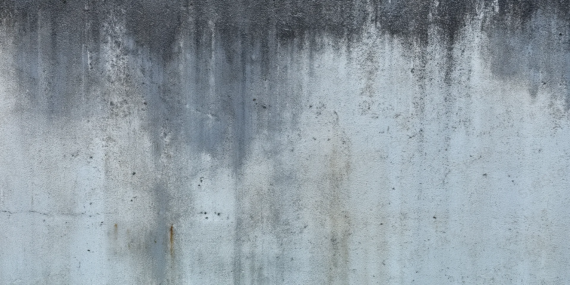 Weathered concrete wall with grime and water stains showing texture and age