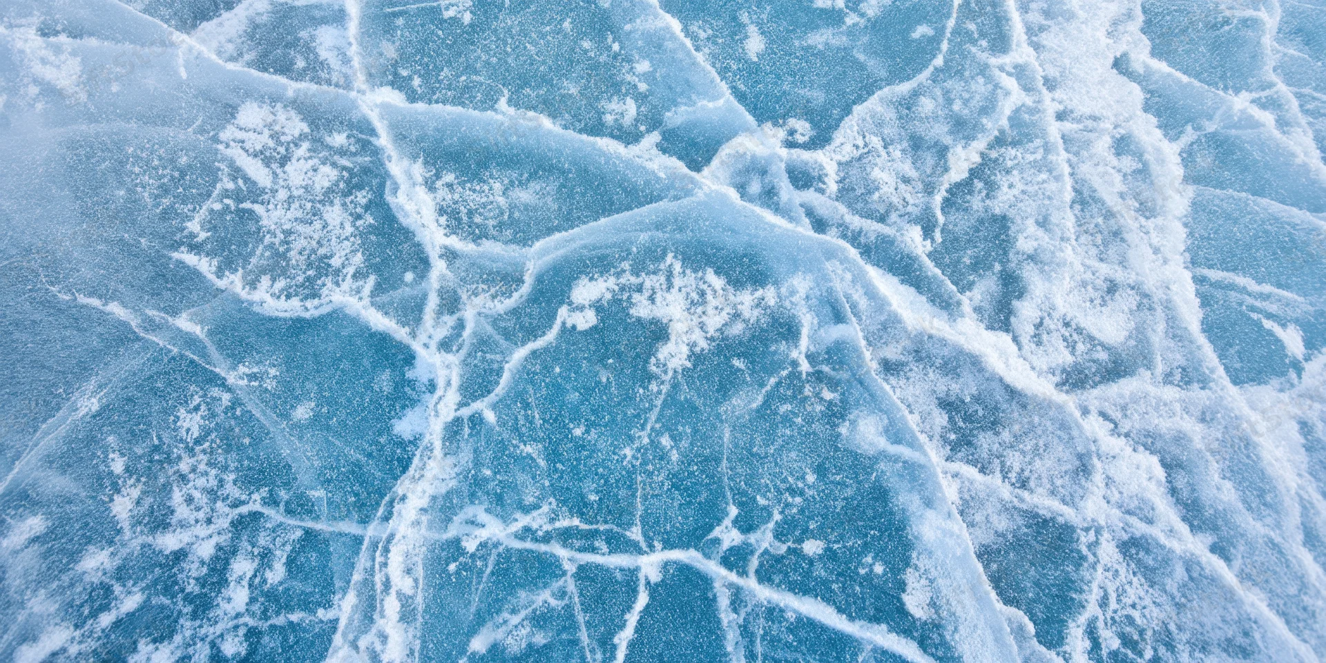 Close-up of blue ice with white cracks and frost covering its surface
