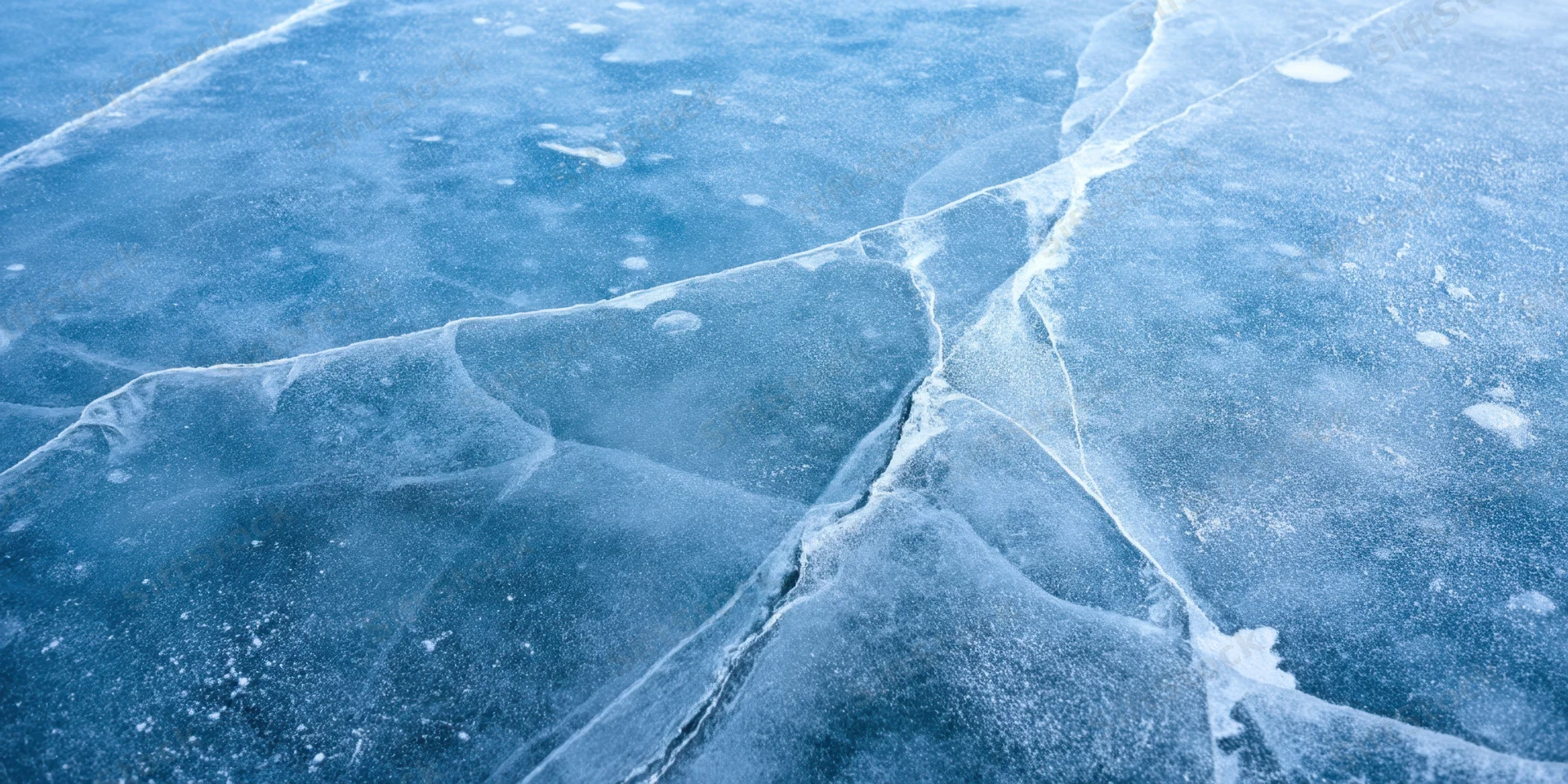 Close-up of blue ice with white cracks and frost covering its surface