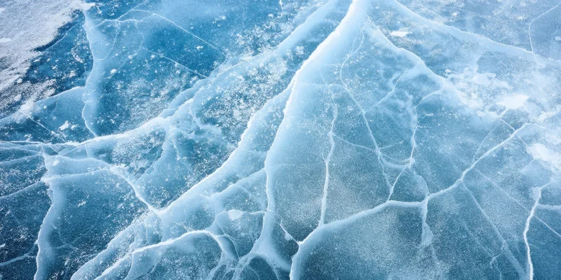 Close-up of blue ice with white cracks and frost covering its surface