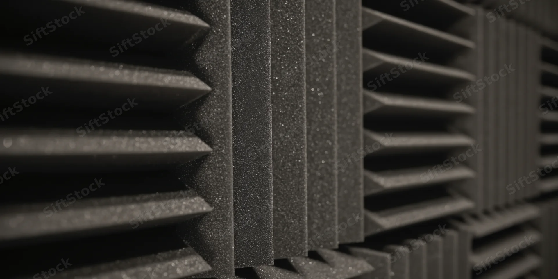 Dark acoustic foam panels arranged in a grid pattern for sound absorption in a studio environment