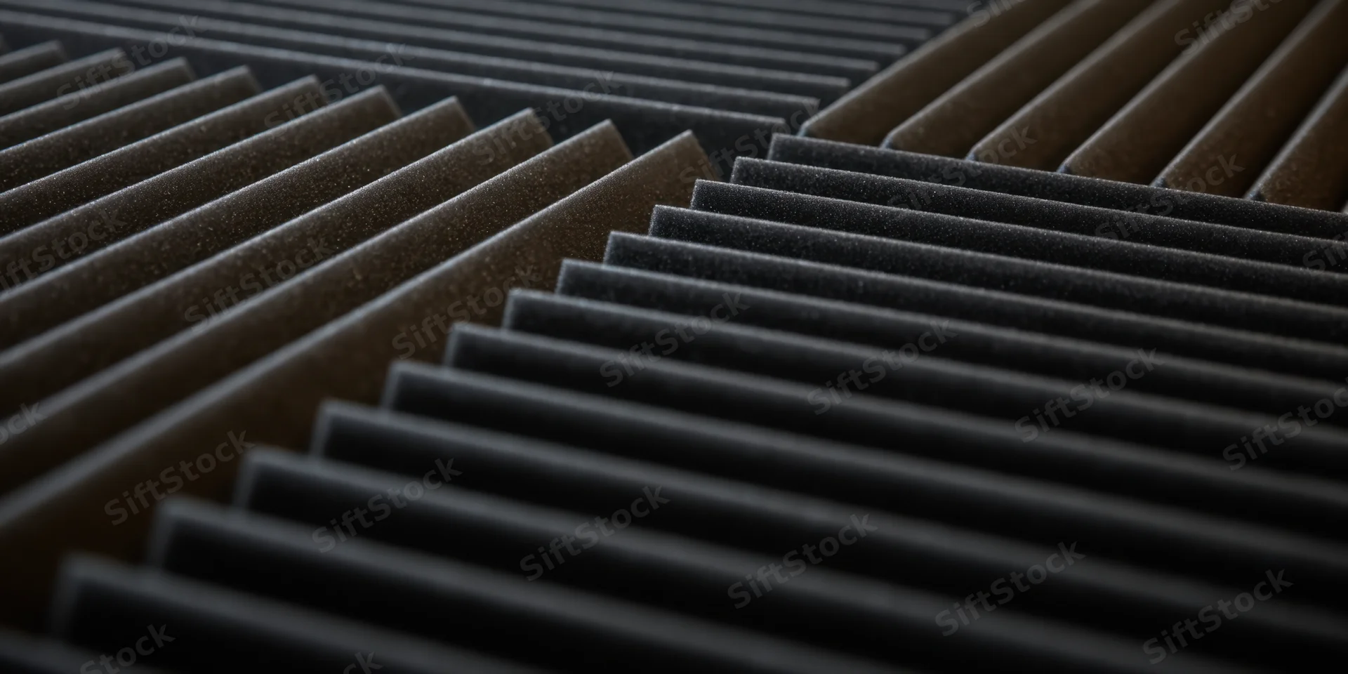 Close-up of dark acoustic foam panels arranged in a grid pattern on a studio wall