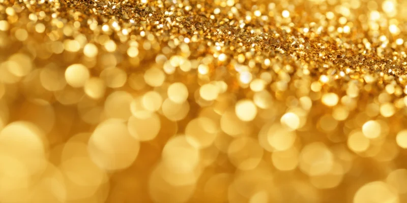 Close-up of shimmering gold glitter with soft bokeh circles in the background