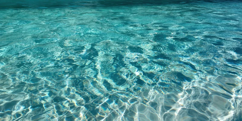 Turquoise pool water with sunlit ripples shimmering on the surface
