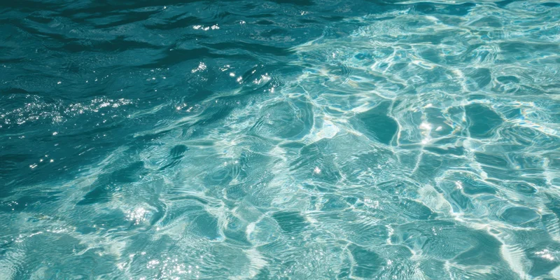 Turquoise pool water with sunlit ripples sparkling on the surface