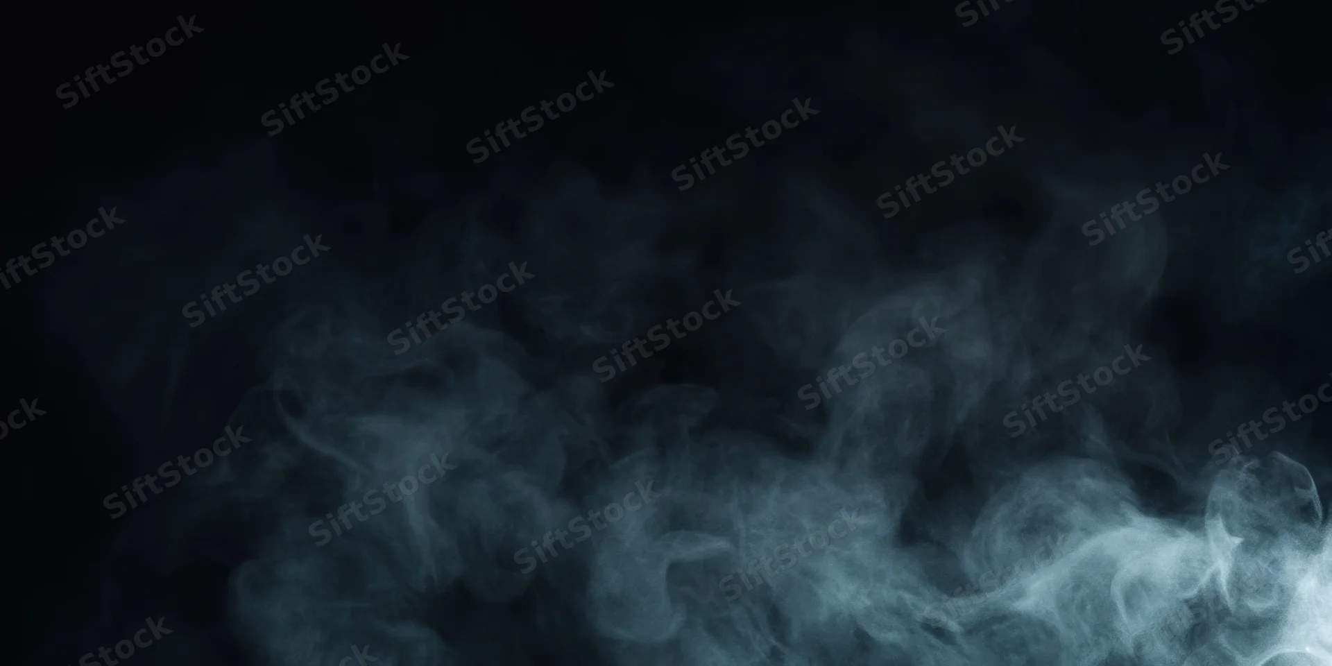 Dark plume of smoke drifting across black background with wispy vapor and copyspace