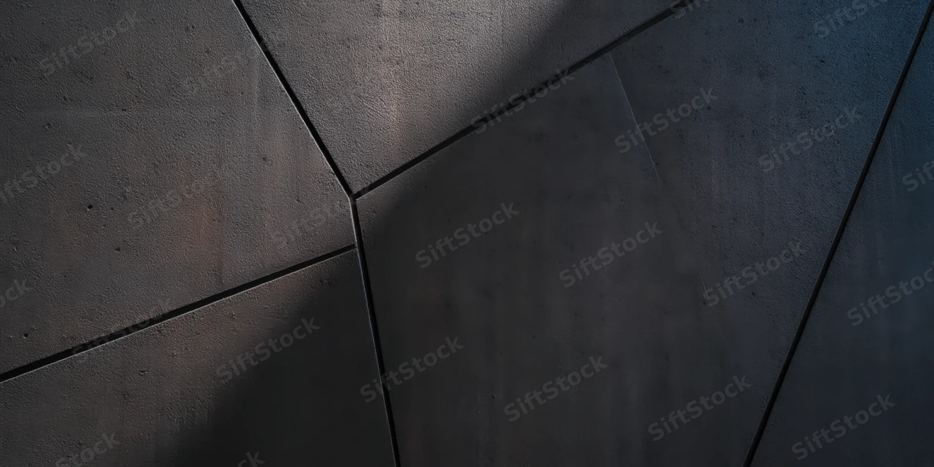 Dark textured concrete wall with intersecting angular seams