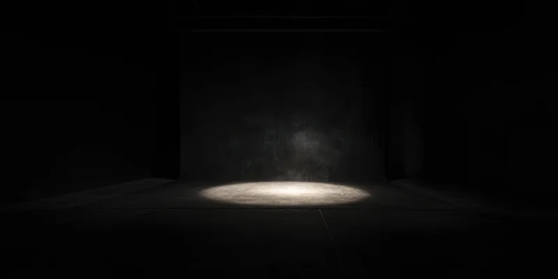 Spotlight on empty black studio floor with centered illumination