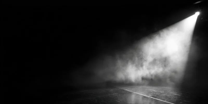 Single spotlight beam cutting through smoke on an empty stage floor