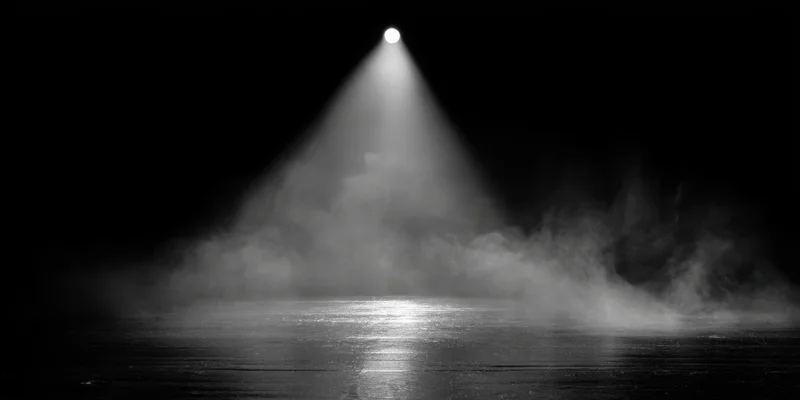 Single spotlight beam illuminating smoke over a glossy stage floor