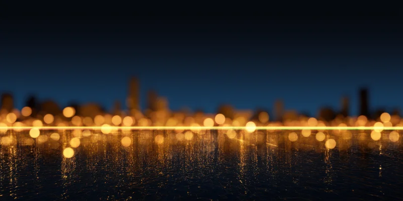 Blurred city lights reflecting on water at night