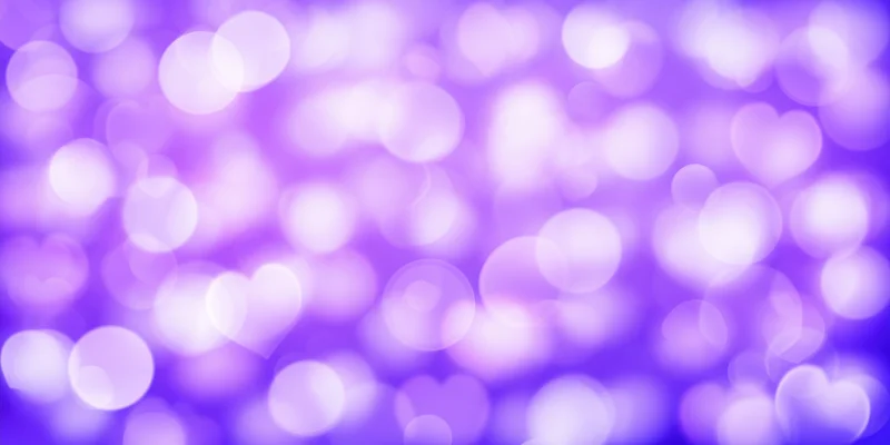 Soft glowing purple bokeh background with heart and circle shapes scattered across the frame