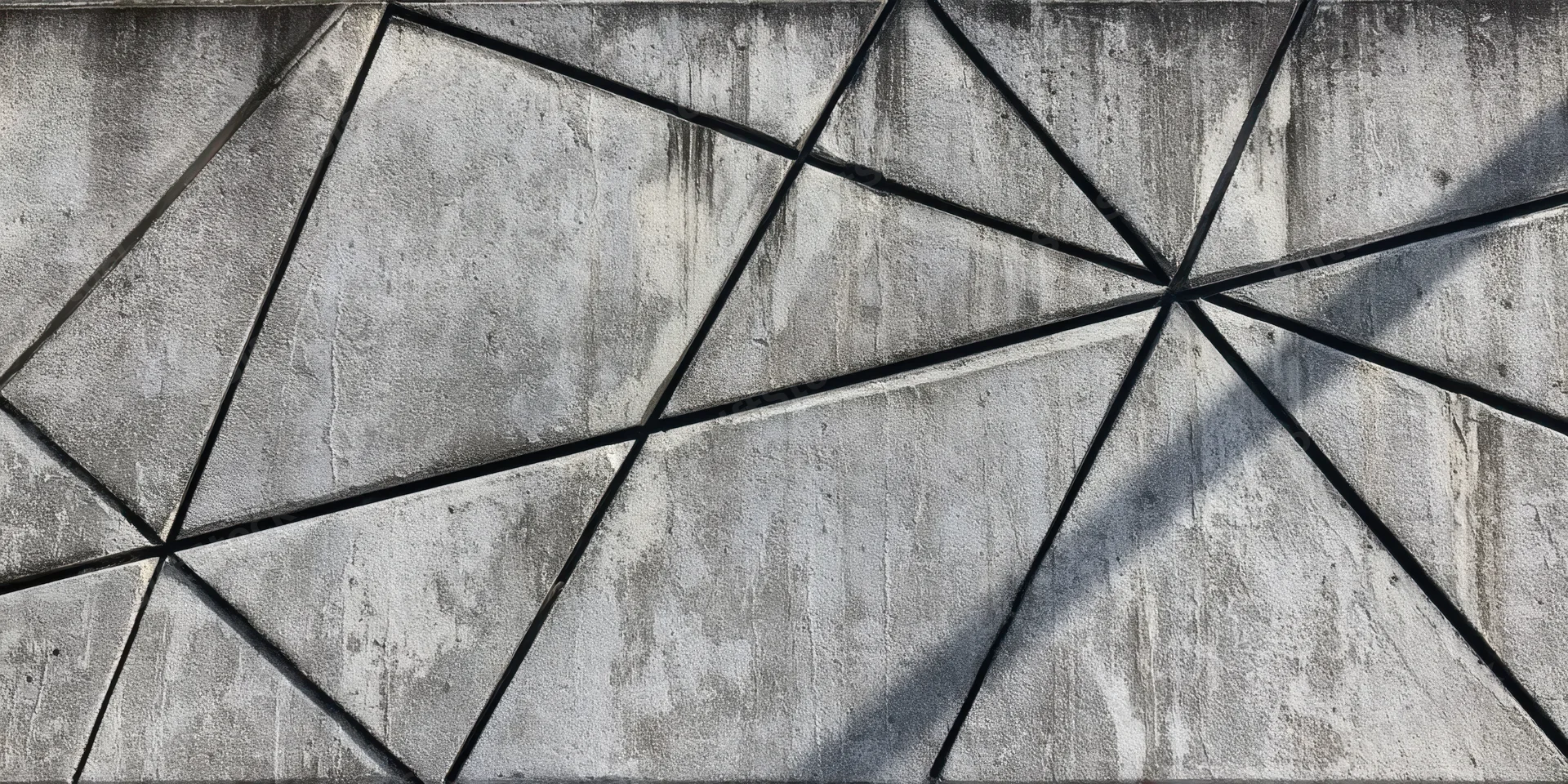 Gray concrete wall with black geometric lines forming triangular pattern