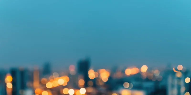 Blurred cityscape at night with bokeh lights and hazy skyline