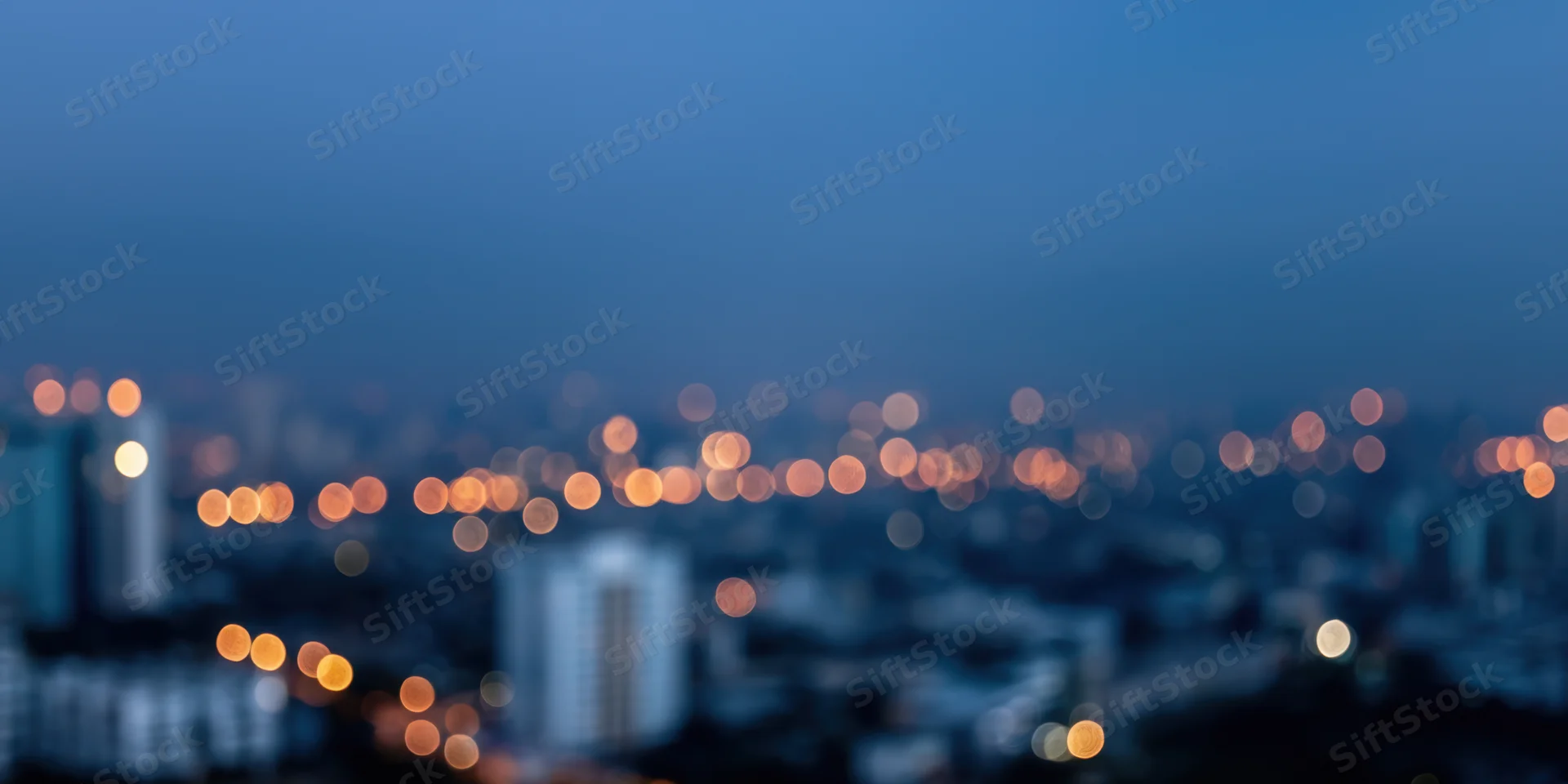 Blurred cityscape at night with bokeh lights and hazy skyline view